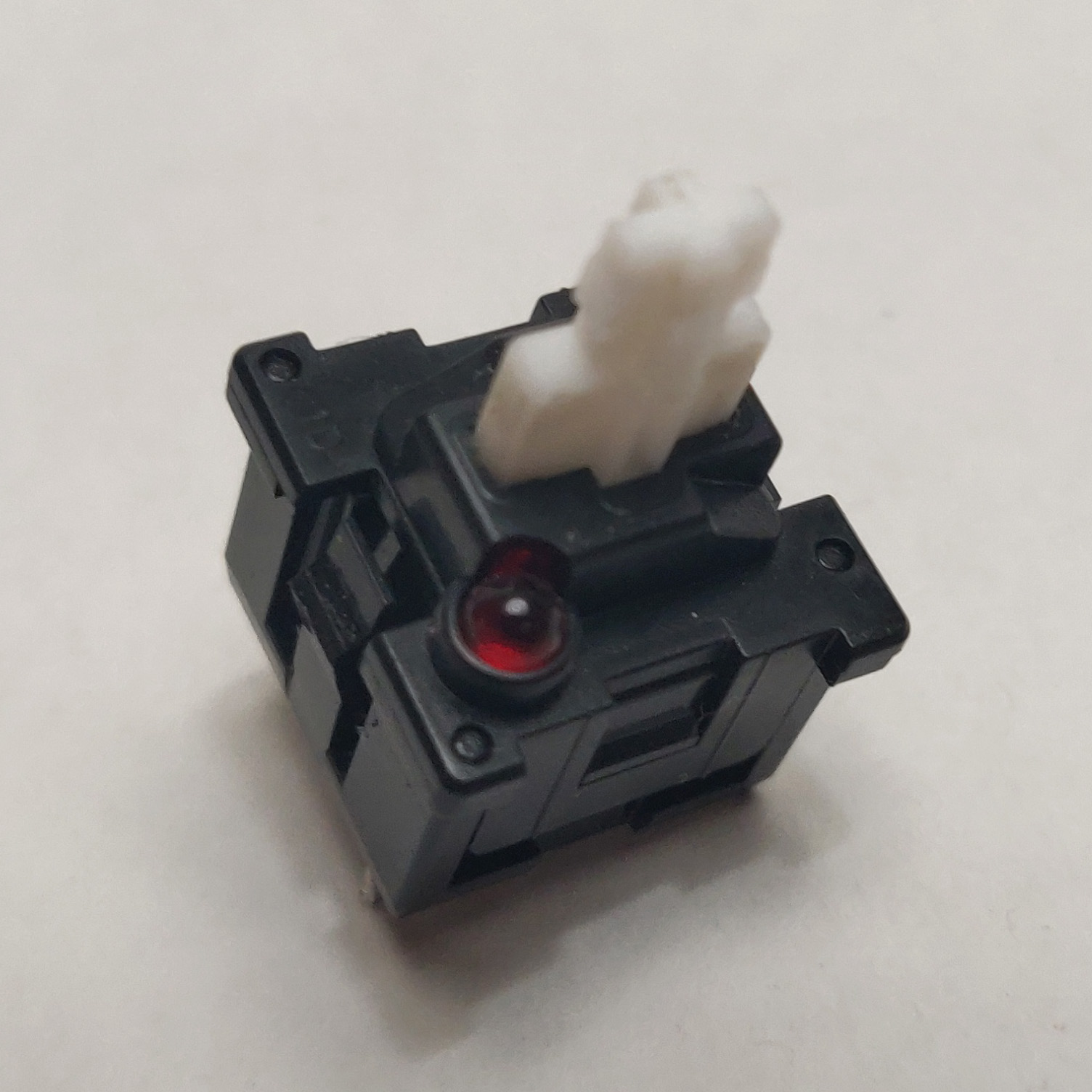 A single desoldered Mitsumi KAM LED switch